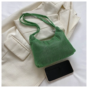 Detail of green rhinestone shoulder bag with metal zipper and size reference to phone
