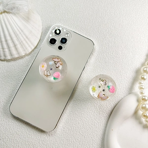 Detail view of transparent resin pop socket featuring pink butterfly and strawberry sequins