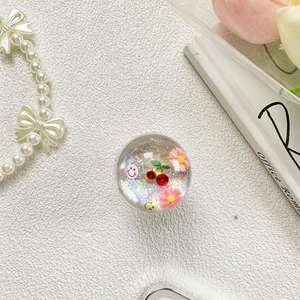 Détail du support de téléphone avec cerise, marguerites et paillettes laser colorées