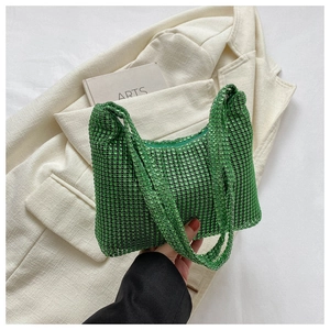 Detail of trendy green rhinestone shoulder bag on a minimalist fashion book