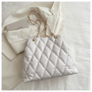 Close-up of white quilted bucket bag with elegant mixed-metal chain strap detail