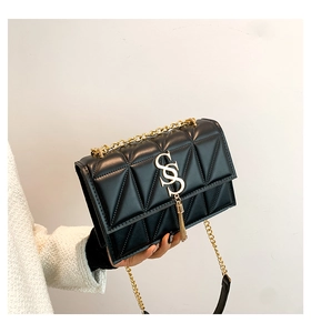 Detail of black quilted leather shoulder bag with gold SS lock and tassel charm