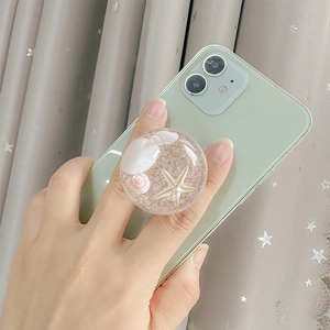 Ocean themed phone socket featuring starfish and seashells on a green smartphone