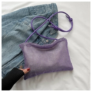 Detail der lila Strass-Netz-Schultertasche mit Knotengurt auf Jeansjacke