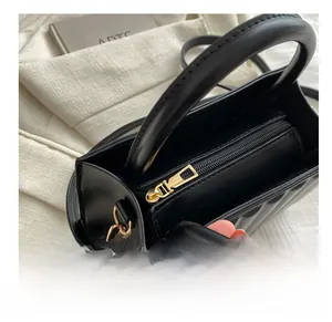 Detail view of the smooth golden zipper and quilted texture on a black handbag