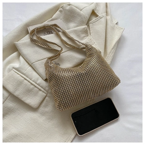 Detail of a gold rhinestone mesh shoulder bag next to a smartphone for size reference