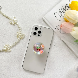 Vue détaillée d'un support de téléphone pailleté 3D cerise et smiley sur smartphone blanc
