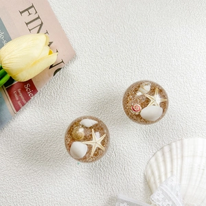 Detailed view of collapsible phone socket with sand, shells and starfish inside