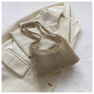 Close-up of sparkling gold rhinestone hobo shoulder bag with luxury shimmering texture