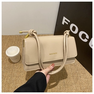 Detail der beigen Kunstledertasche mit geknoteten Riemen und goldenem MISSMINI Logoaufdruck