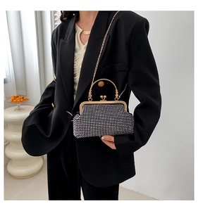 Close-up of elegant rhinestone evening clutch with gold handle and delicate chain strap