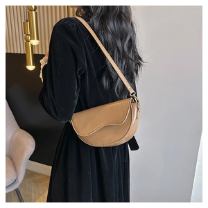 Sac à bandoulière demi-lune en cuir marron minimaliste avec coutures rétro sur modèle