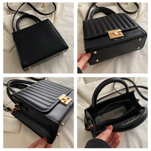 Detail view of black quilted crossbody bag with gold hardware and internal compartments