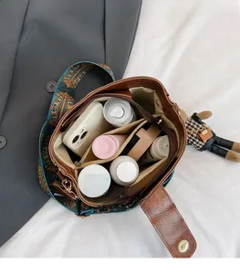 Macro view of brown retro tote bag interior with multiple compartments and wide strap