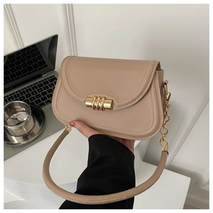 Close-up of a beige flap shoulder bag featuring a unique gold spiral twist-lock closure