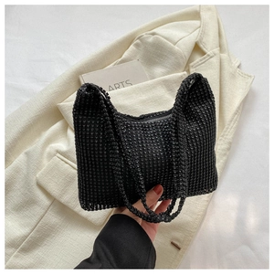 Close-up of black rhinestone handbag featuring dense diamond texture and zipper detail