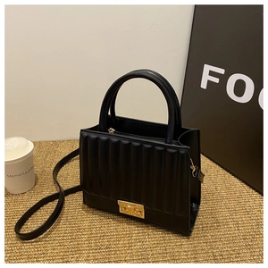 Vue détaillée de la texture plissée verticale et du fermoir doré de ce sac bandoulière noir