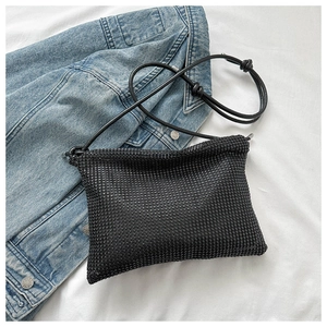 Detailansicht der schwarzen Strass-Schultertasche mit modisch geknotetem Riemen