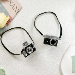 Detail of mini retro camera phone sockets in black and silver with hanging cords