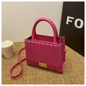 Détail d'un sac à main rose matelassé avec fermoir doré et bandoulière amovible