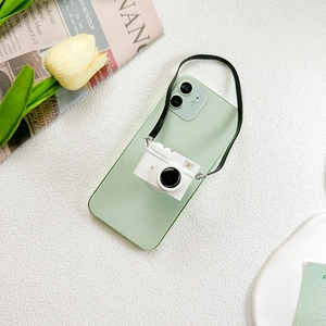 Close-up of retro camera-shaped phone socket grip on a mint green smartphone