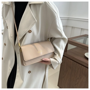Detail der minimalistischen beige Handtasche mit goldenem MISSMINI Logo und feinen Nähten