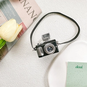 Close-up of a retro camera-shaped phone grip with realistic lens and lanyard details