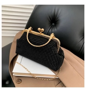 Detail of vintage black rhinestone clutch with gold embossed clasp and chain strap