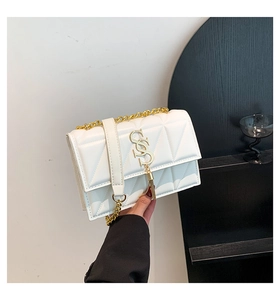 Detail of cream quilted shoulder bag with gold S-logo, chain strap and tassel