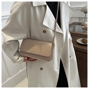 Detailansicht einer beigen Leder-Umhängetasche mit elegantem goldenen Kettenriemen-Akzent