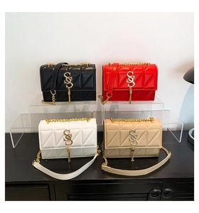 Close-up of quilted crossbody bags in multiple colors with gold chain straps and tassels