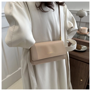 Detail einer minimalistischen beige Ledertasche mit eleganter Goldprägung und feiner Naht