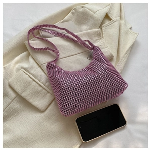 Close-up of pink rhinestone handbag on beige suit jacket with phone for size reference