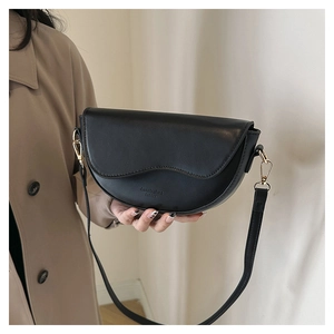 Détail du sac bandoulière demi-lune noir avec boucles dorées et surpiqûres fines