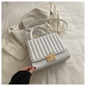 Vue de dessus d'un sac à main blanc minimaliste avec rayures verticales dorées