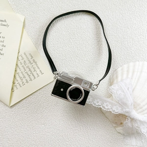 Detail shot of vintage camera phone stand with strap on decorative retro paper background