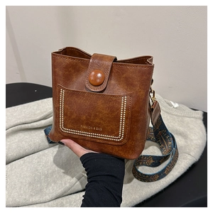 Brown vintage PU leather bucket bag with gold rivets and jacquard shoulder strap