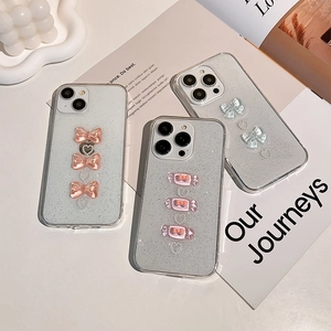 Glitter iPhone case with cute resin bow and candy charms on white wave tray display