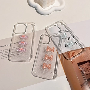 Close-up of clear iPhone case featuring 3D resin candy, bows, and sparkling silver glitter
