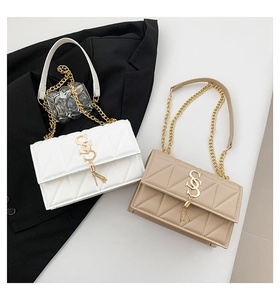 Detail of quilted shoulder bags with gold SS logo, fringe, and metal chain straps