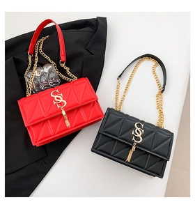 Close-up of quilted leather handbags in red and black with gold interlocking logo and tassel