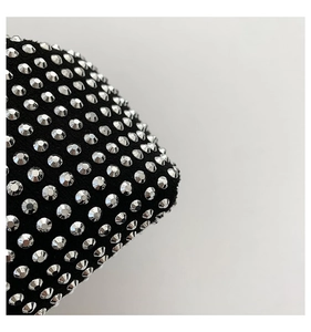 Macro shot of silver rhinestones on black fabric for a luxury crossbody bag detail