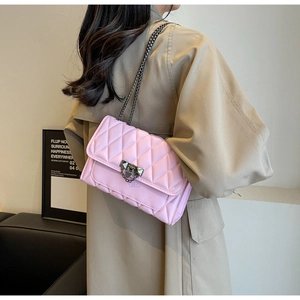 Borsa a tracolla rosa trapuntata con catena su modella in una stanza moderna minimalista