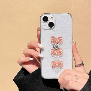 Close-up of glitter iPhone case with three pink resin bows and pearl heart accents