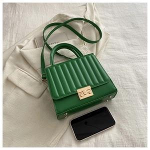 Détail du sac bandoulière vert carré avec coutures verticales et fermoir doré élégant