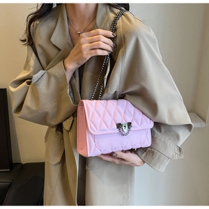 Dettaglio borsa rosa trapuntata con catena, chiusura con borchie e finitura in pelle