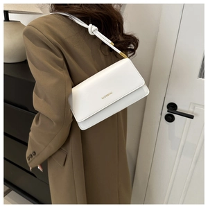 Nahaufnahme weiße Ledertasche mit geknotetem Riemen und goldener Hardware