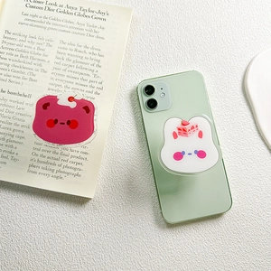 Cute cartoon bear and rabbit collapsible phone grips on a green phone case back