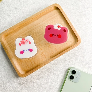 Close-up of cute acrylic bear and rabbit retractable phone grips on a wooden tray