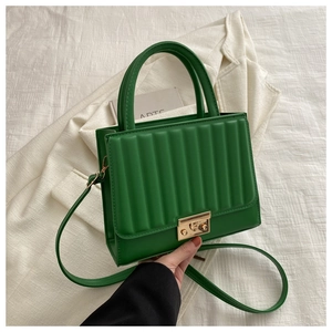 Détail du sac à main plissé vert émeraude avec boucle dorée et bandoulière réglable
